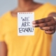 woman holding we are equal sign