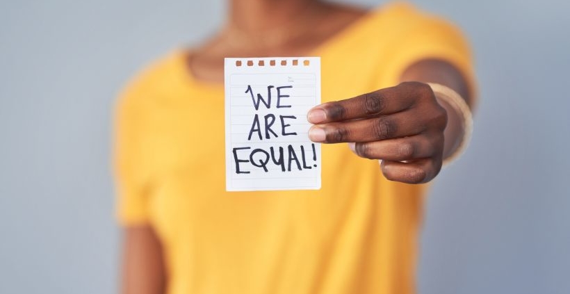woman holding we are equal sign